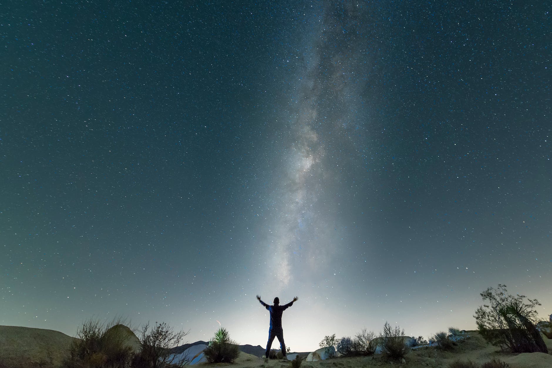 a man standing under a starry night sky